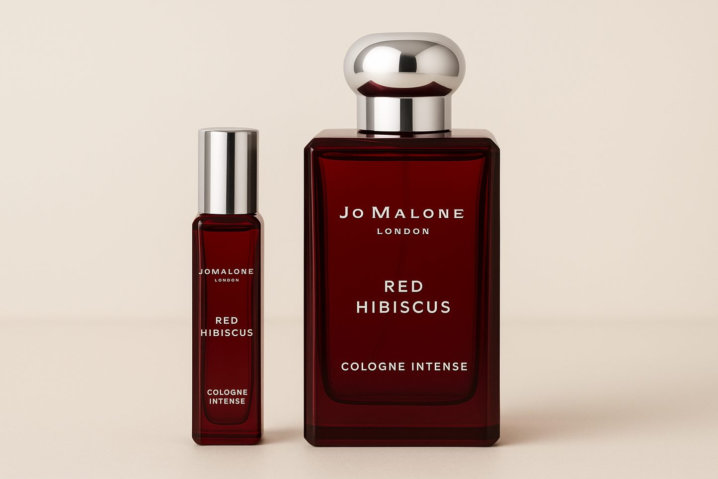 Jo Malone Red Hibiscus Cologne Intense 12 ml näyte Jo Malone Red Hibiscus Cologne Intensen 100 ml hajuvesipullon vieressä, jossa on valkoinen kirjoitus tummanpunaisessa pullossa
