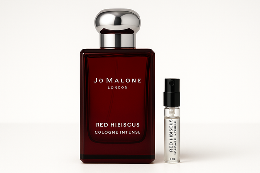 Jo Malone Red Hibiscus Cologne Intense 1 ml näyte Jo Malone Red Hibiscus Cologne Intensen 100 ml hajuvesipullon vieressä, jossa on valkoinen kirjoitus tummanpunaisessa pullossa